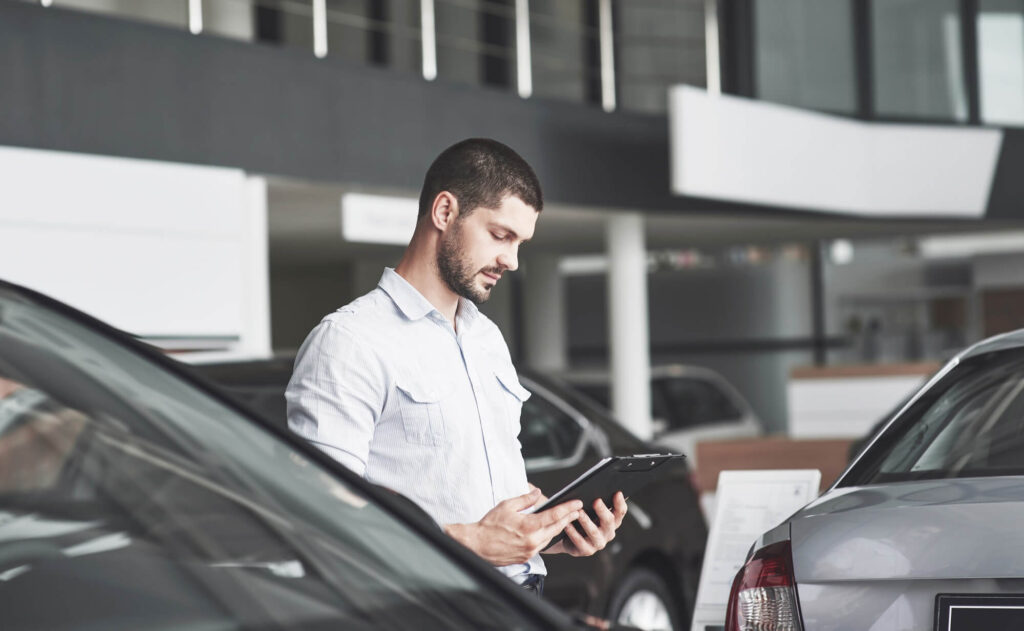 un ragazzo sta leggendo un contratto per capire quale soluzione tra leasing e noleggio possa essere quella più idonea alle sue esigenze