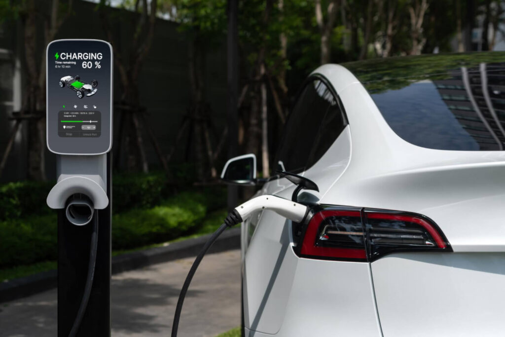 Auto elettrica in ricarica presso una colonnina, con display digitale attivo, che evidenzia l’importanza dell’autonomia auto elettriche per una mobilità efficiente e sostenibile.