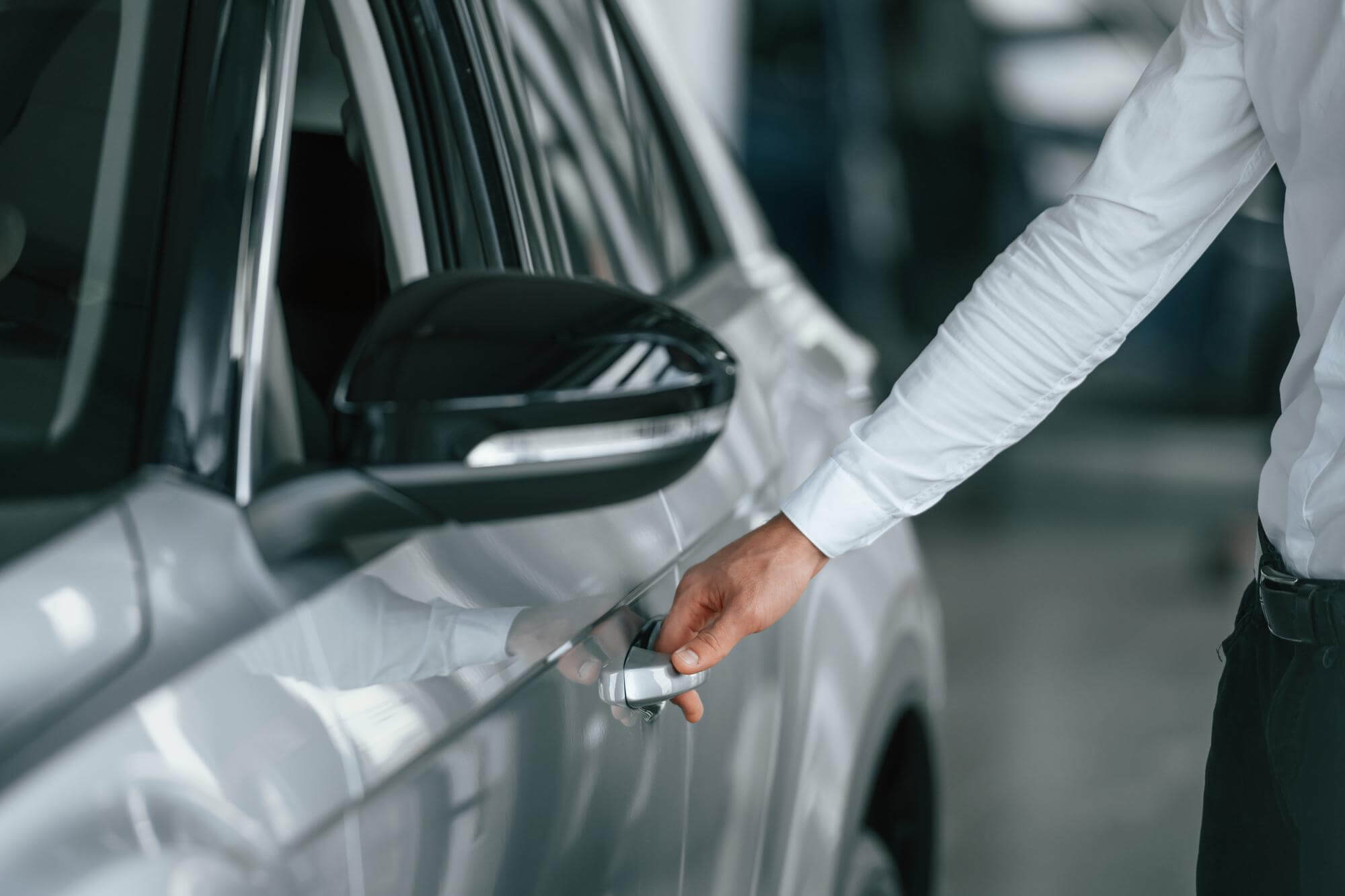 Un uomo elegante sta per aprire la porta di un'auto