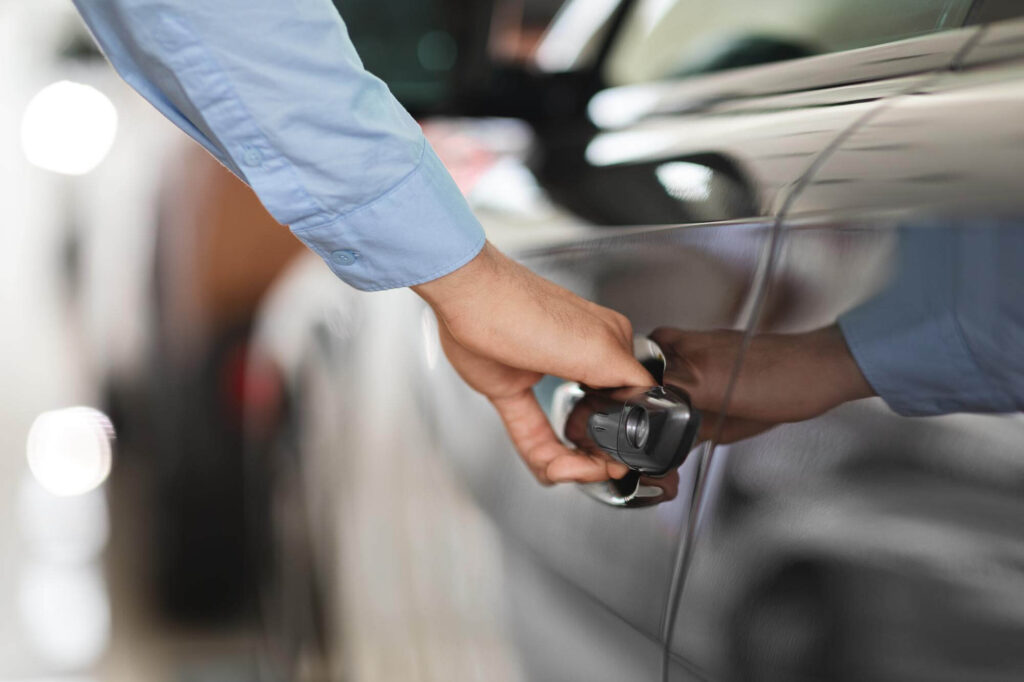 Mano di una persona che sta aprendo la portiera di un'auto